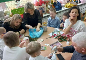 Dzieci wspólnie z rodzicami przygotowują świąteczne lampiony.
