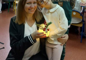 Dziewczynki wspólnie z mamą prezentuje wykonany lampion.