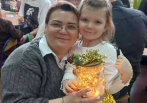 Dziewczynka razem z mamą prezentuje wykonany lampion.