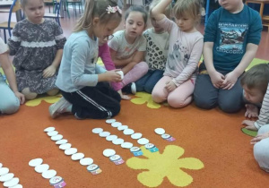 Dziewczynka układa bałwankowe kule według kodu