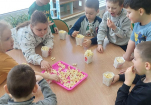Żabki wkładają popcorn do swoich pudełeczek