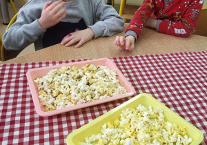 Dzieci jedzą popcorn