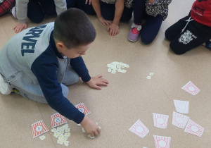 Żabki wkładają do pudełek odpowiednią ilość popcornu