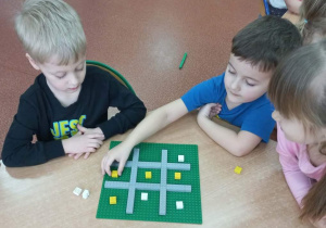 Chłopcy grają w Kółko i krzyżyk.