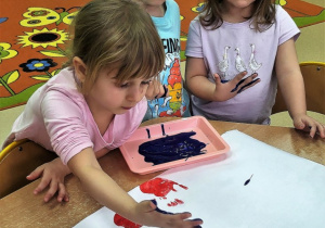 Dzieci podpisują swoją dłonią zasady bezpiecznych ferii