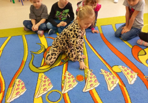 Dziewczynka przelicza kawałki pizzy.