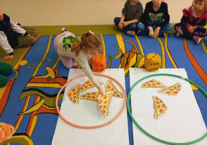 Dzieci dobierają odpowiednią ilość pizzy do ilości kropek na kostce.