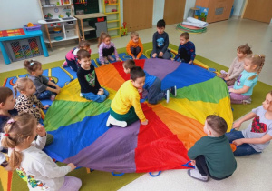 Dzieci tworzą pizze na chuście animacyjnej.