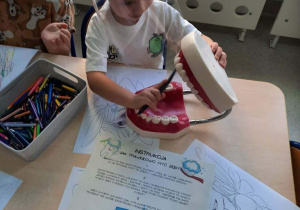 Chłopiec udziela instrukcji: Jak prawidłowo myć zęby.