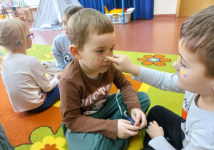 Chłopiec przelicza piegi.