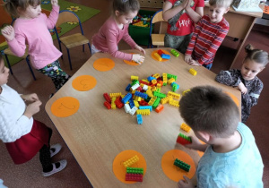 Dzieci dopasowują liczbę klocków do podanych cyfr