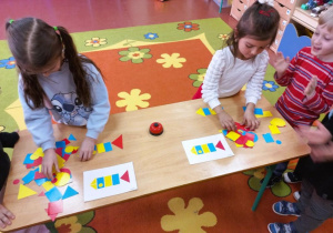 Dziewczynki układają obrazek z figur geometrycznych