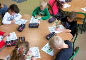 Dzieci malują kolorowanki dotyczae programu