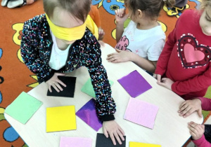 Dziewczynka rozpoznaje kartoniki po dotyku