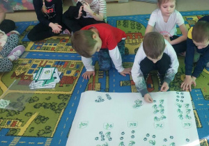 Chłopiec dopasowuje ilość pand i ich tropów do cyfry