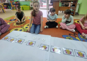 Dziewczynka wykonuje działanie matematyczne wykorzystując sylwety motyli.