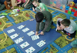 Chłopiec przelicza muchy i spinaczem zaznacza odpowiednią cyfrę