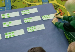 Chłppiec przelicza żabki i wpisuje odpowiednią cyfrę