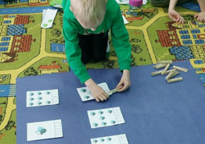 Chłopiec przelicza muchy i spinaczem zaznacza odpowiednią cyfrę