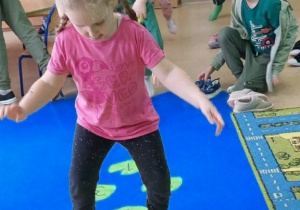 Dziewczynka gra w żabkową grę w klasy