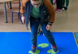 Chłopiec gra w żabkowe klasy