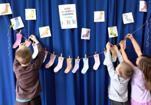 Dzieci zawieszają na sznurku wykonane prace