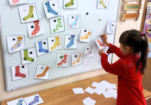 Dziewczynka zdejmuje skarpetkę zgodnie z usłyszaną instrukcją