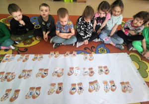 Dziewczynka szuka skarpetki wg. opisu.