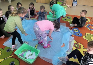 Dziewczynki"łowią skarpetki"z użyciem wędek.