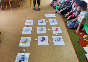 Chłopiec prezentuje"drogę skarpetek"ułożoną wg. kodu.