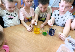 Chłopcy mieszają kolory przy użyciu pipet