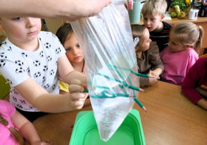 Chłopiec przebija woreczek ołówkiem