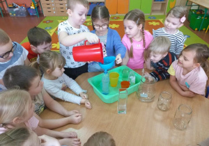 Dzieci napełniają wodą pojemniki