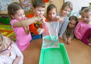 Dzieci wykonują doświadczenie z woreczkiem strunowym