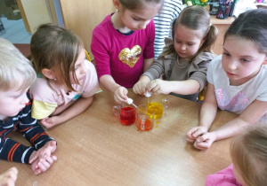 Dziewczynki mieszają zabarwioną wodę