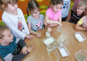 Dziewczynki rozpuszczają w wodzie cukier i mąkę