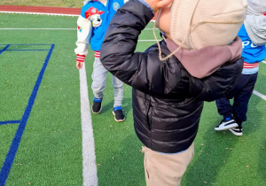 Chłopcy obserwują niebo przez papierowe lornetki.