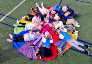 Dzieci obserwują niebo leżąc na chuście animacyjnej.