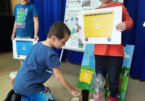 Chłopiec segreguje odpady.