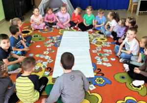 Przedszkolaki słuchają instrukcji do wykonania zadania.