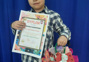 Chłopiec z dyplomem i wykonaną torebką