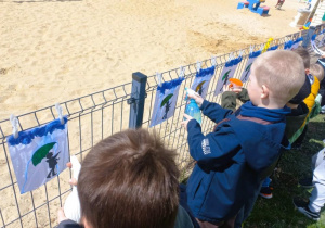 Chłopcy wykonują eksperyment z bibuły i spryskiwacza.