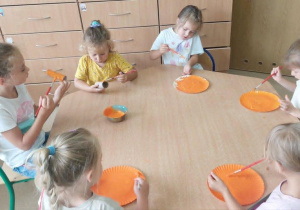 Malujemy talerzyki na pomarańczowo.