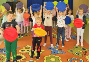 Dzieci biorą udział w zabawie muzyczno-ruchowej.