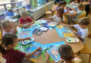 Motylki wykonują pracę plastyczną z wykorzystaniem farb i patyczków higienicznych.