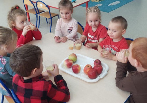 Dzieci degustują zrobiony sok jabłkowy.