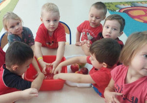 Dzieci myją jabłka.