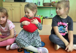 Dziewczynka wręcza koleżance serce.