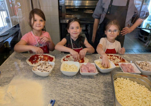Dziewczynki układają dodatki na pizzy