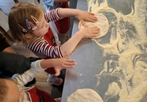 Dziewczynki przygotowują spody do pizzy.